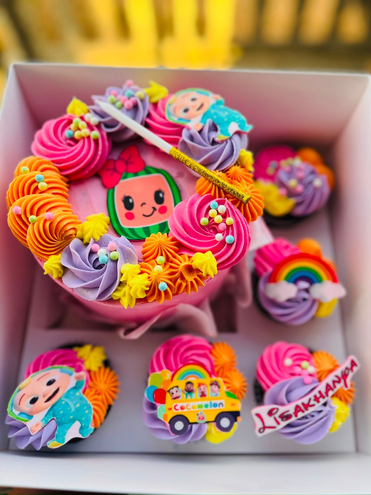 A colourful Cocomelon rainbow bento cake with matching cupcakes by Baked by Buhlebenkosi