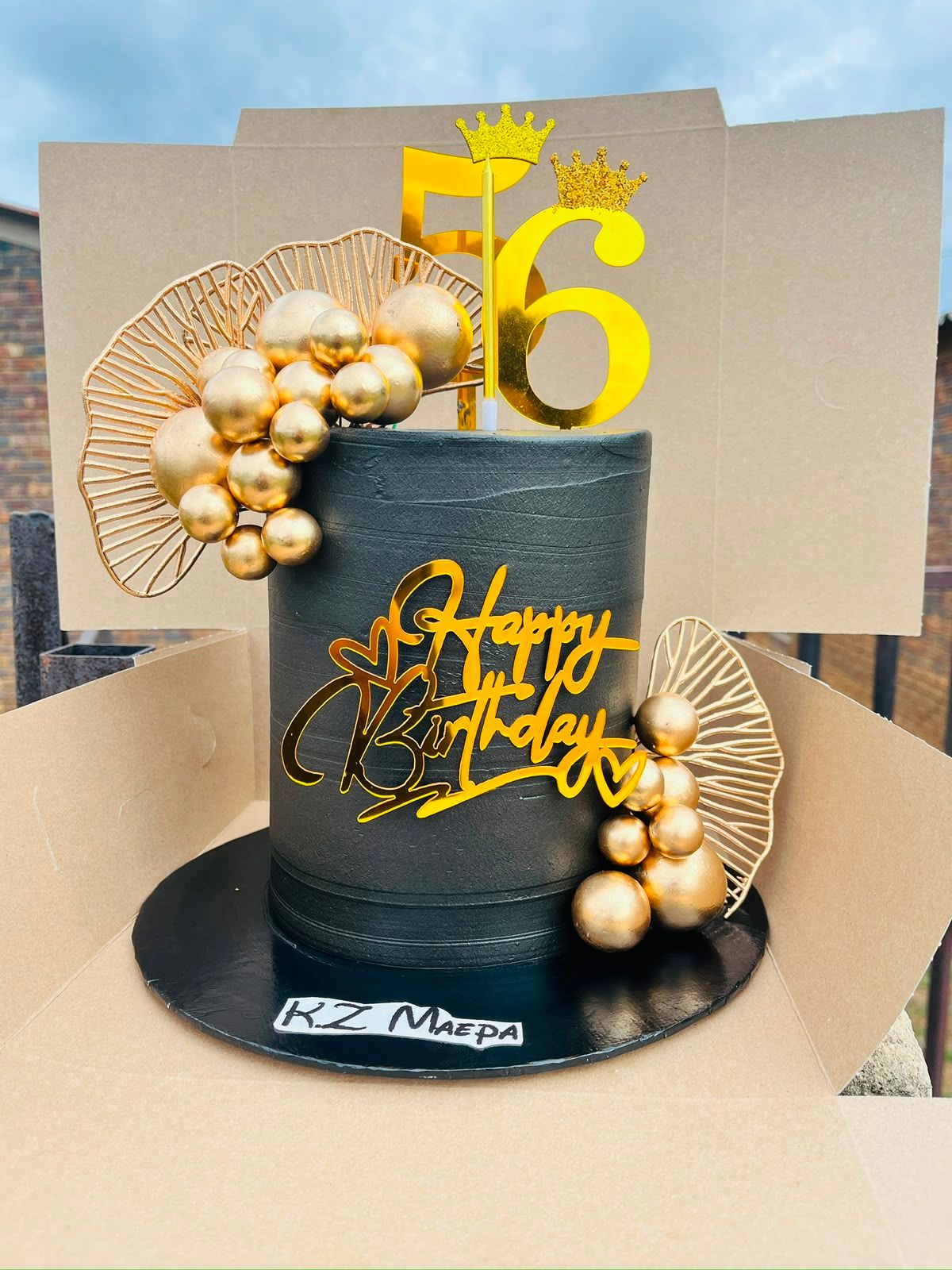 A dramatic black-and-gold milestone birthday cake by Baked by Buhlebenkosi